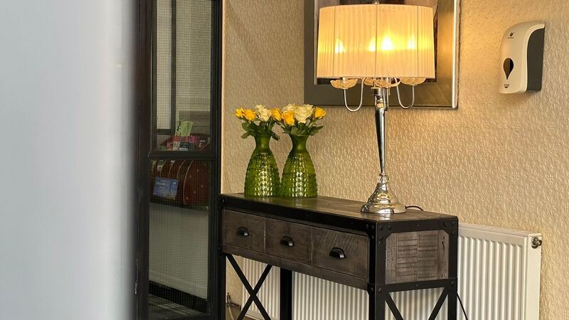 A table lamp and yellow roses in the entrance hall.