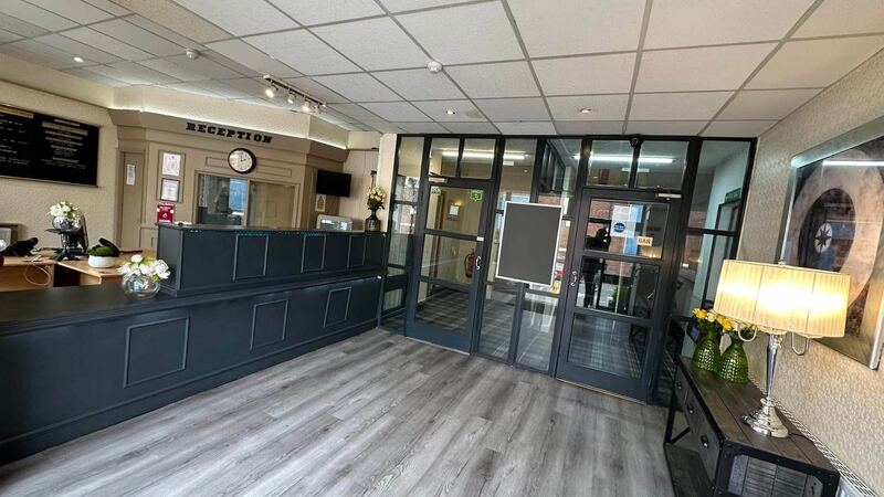 The reception area with its dark grey desk and wood-effect flooring.